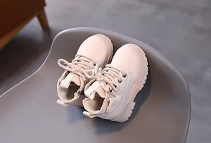 Close-up detail of cream British style children's Martin boots with side zipper design
