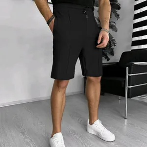 Close-up of black waffle texture men's shorts with drawstring waist and pockets.