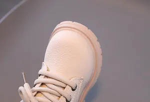 Macro detail of cream kids Martin boots showing high-quality textured leather and laces