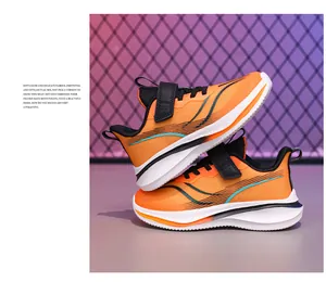 Gros plan de chaussures de course orange pour garçons avec maille respirante et velcro