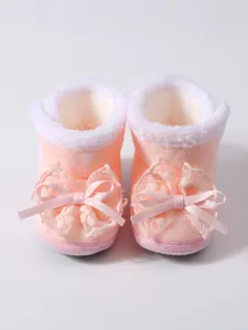 Detailansicht von rosa Babyschuhen mit weichem Fleece-Futter und Spitzenschleifen