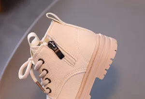 Detail of cream children's Martin boot with side zipper and leather texture