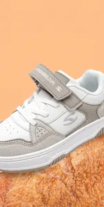 Nahaufnahme von Kinderschuhen mit Klettverschluss und Logo-Detail.