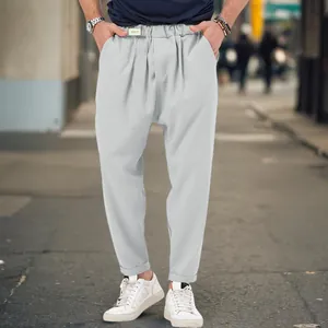 Close-up detail of men's loose harem drop crotch casual pants in light gray for urban street style