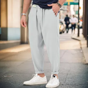 Close-up detail of men's casual light grey harem pants in a loose urban street style