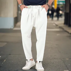 Detailed view of white men's casual drop crotch harem pants in a trendy street style