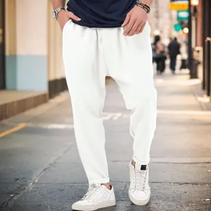 Close-up detail of men's white drop crotch harem pants styled for casual urban fashion