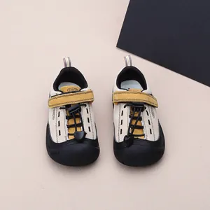 Detailansicht von beigen Kinder-Outdoor-Sportschuhen mit gelbem Klettverschluss