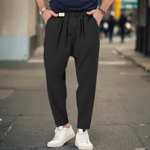 Detailed street style view of men's black drop crotch harem pants with elastic waist