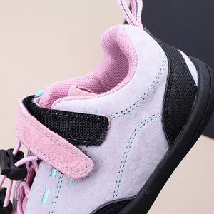 Detailaufnahme des pinkfarbenen Wildleders und des Klettverschlusses am Kinderschuh.
