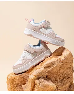 Detailed macro shot of two stylish children's sneakers stacked on a natural rock prop