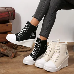 Detailed view of stylish women's wedge high-top canvas sneakers in black and beige.