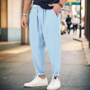 Detail shot featuring men's light blue casual harem pants worn on a city street