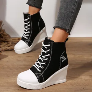 Side view detail of black and white high-top canvas wedge sneakers with butterfly embroidery.
