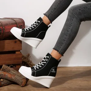Detail view of women's high-top wedge canvas shoes in classic black and white style