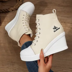 Detail view of women's beige high-top wedge canvas shoes featuring lace-up design