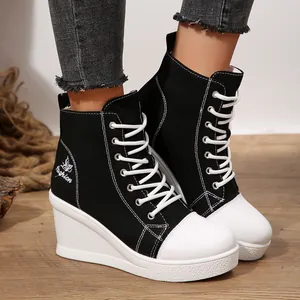 Detailed view of women's black and white high-top wedge canvas shoes with lace-up design.