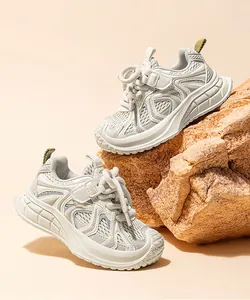 Gros plan de baskets chunky beiges pour femmes sur des rochers texturés naturels en gros plan