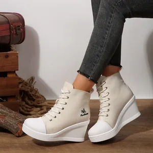 Close-up detail of stylish white wedge high-top canvas sneakers with butterfly logo