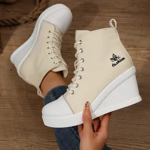 Detailed view of women's beige wedge canvas high-top sneakers with platform soles