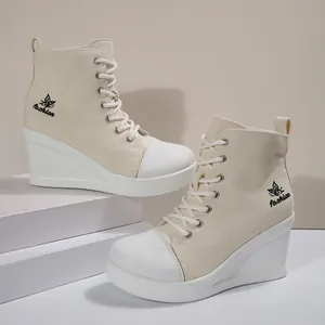 Detailed side view of stylish cream wedge canvas sneakers with butterfly embroidery