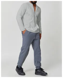 Full body view of man wearing light grey hooded sun protection sports t-shirt and pants