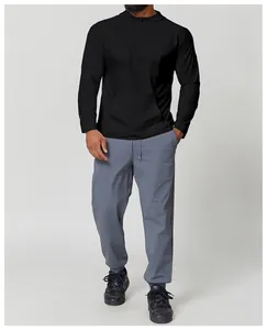 Full body view of men's black hooded sports t-shirt and grey lightweight hiking pants set
