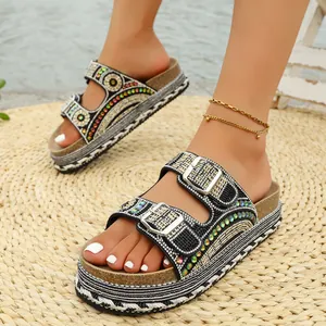 Primer plano de sandalias bohemias de plataforma con pedrería y suelas de cuerda.