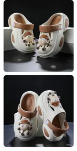 Detail view of children's non-slip clogs featuring cute character charms and brown straps