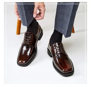 Détail de chaussures derby brunes brillantes pour hommes à bout carré avec costume.