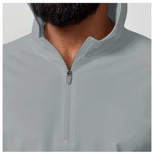 Close-up of a light gray hooded sports shirt with a quarter-zip collar detail.