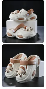 Detail view of beige kids clog shoes with cute sheep charms and brown accents.