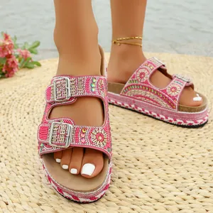 Vista detallada de sandalias de plataforma rosa con perlas, hebillas de strass y corcho