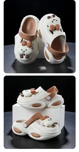 Detailed close-up of white and brown platform clogs with cute cartoon bear charms.