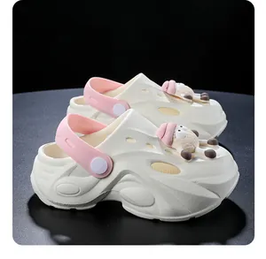 Zijaanzicht van kinderklompen in gebroken wit met roze bandjes en schattige schaapbedels.