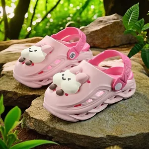 Pink kids cartoon clogs with cute marshmallow character charms in outdoor nature