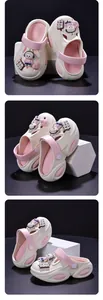Viste dettagliate di zoccoli beige da bambina con cinturini rosa e ciondoli a forma di coniglio.