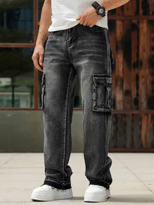 Detailed view of men's loose fit black washed cargo denim jeans with side flap pockets.