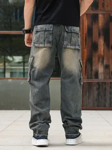 Back view of men's loose fit multi-pocket denim cargo pants with distressed vintage wash