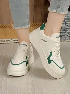 Λεπτομερής όψη γυναικείων λευκών sneakers με πλατφόρμα και πράσινες λεπτομέρειες
