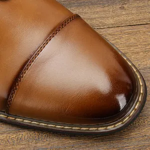 Close-up of brown leather dress shoe showing cap-toe stitching and polished texture
