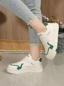 Κομψά γυναικεία δερμάτινα sneakers με πλατφόρμα σε λευκό και πράσινο χρώμα σε μοντέλο