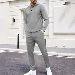 Man wearing a grey waffle knit hooded tracksuit set standing on an outdoor city street