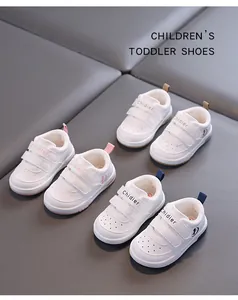 Detailed view of white toddler sneakers with velcro straps and breathable holes