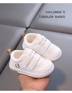 Detailed close-up of white toddler walking shoes with soft soles and velcro strap design