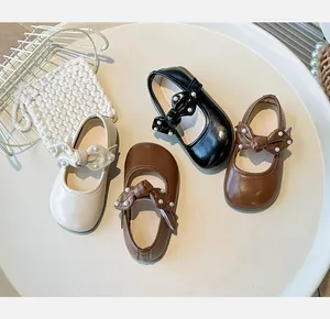 Detailansicht von Mary Jane-Kinderschuhen mit eleganten Schleifen und perlenartigen Nieten