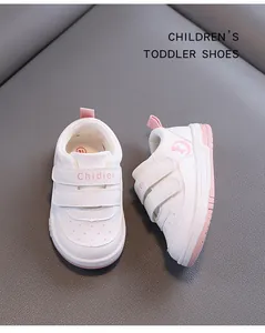 Detailed close-up view of white leather toddler walking shoes with pink Velcro straps