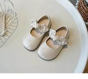 Detailansicht der cremeweißen Mädchen-Mary-Jane-Schuhe mit eleganter Schleife und Perlen