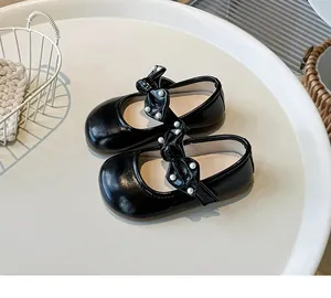 Detailansicht schwarzer Mädchen-Mary-Janes mit perlenbesetzter Schleife
