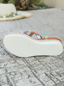 Vue détaillée de la semelle et du motif floral de la sandale compensée.